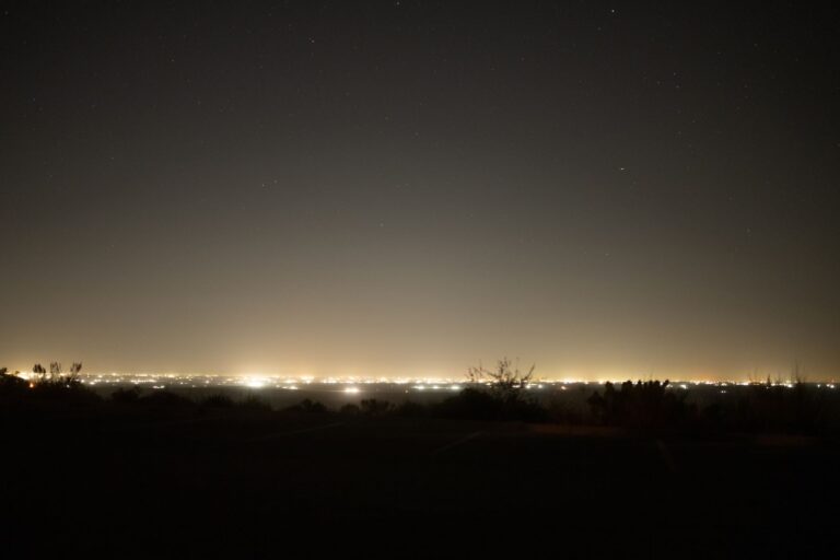 An image of a horizon at night with many light sources visible.