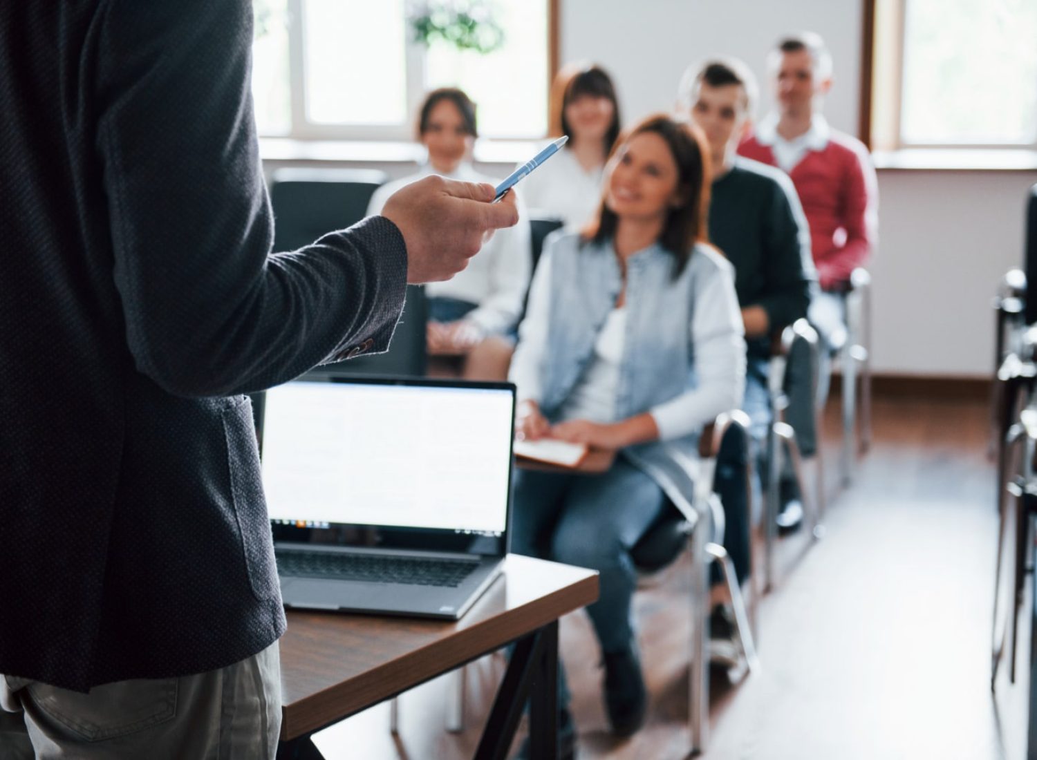 everyone-is-smiling-listens-group-people-business-conference-modern-classroom-daytime-min
